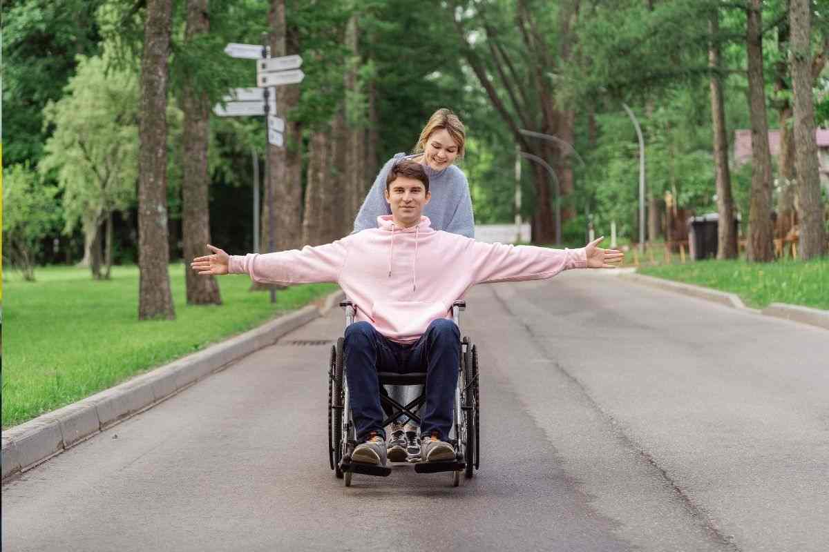 Ragazzo in carrozzina passeggia al parco