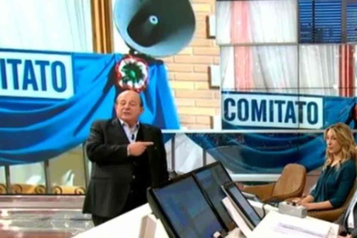 Giancarlo Magalli indica la scritta Comitato